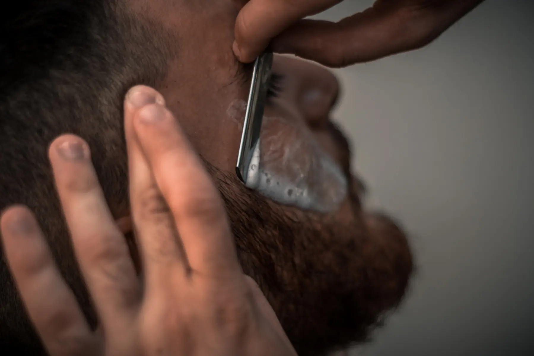 Barber poprawiający brodę klienta
