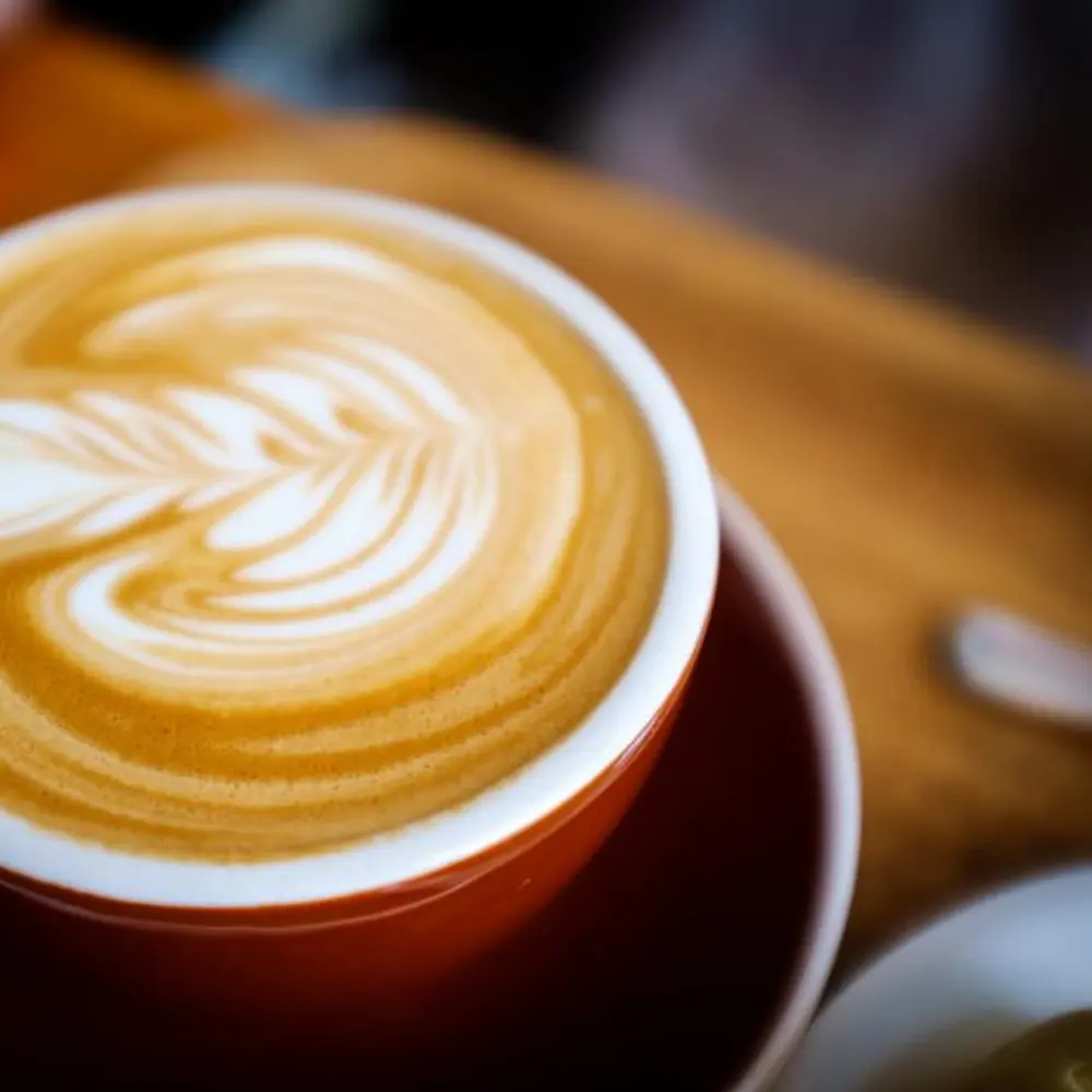 Cappuccino z latte art w czerwonej filiżance